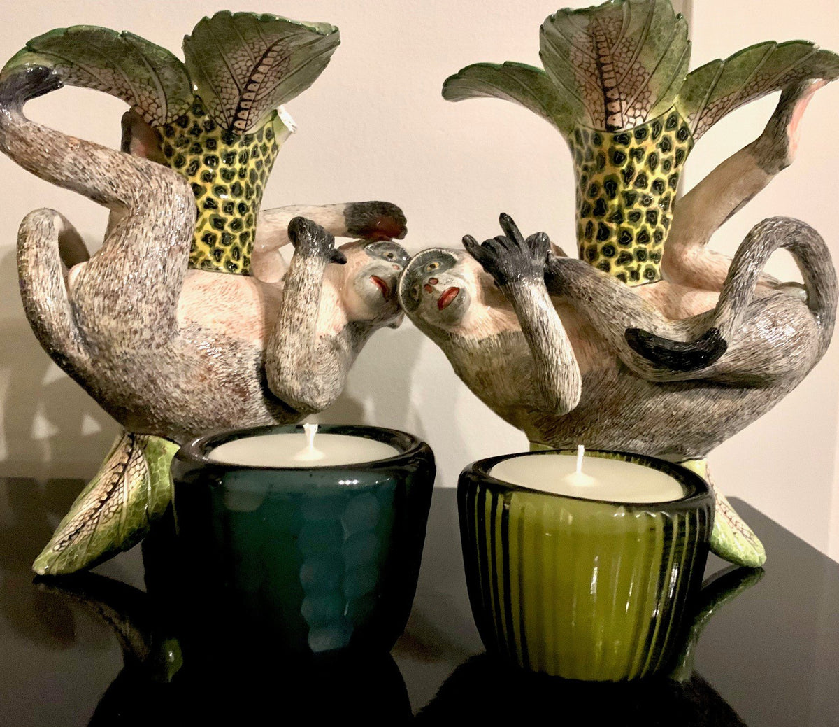 Candles in green pots held by ceramic figures