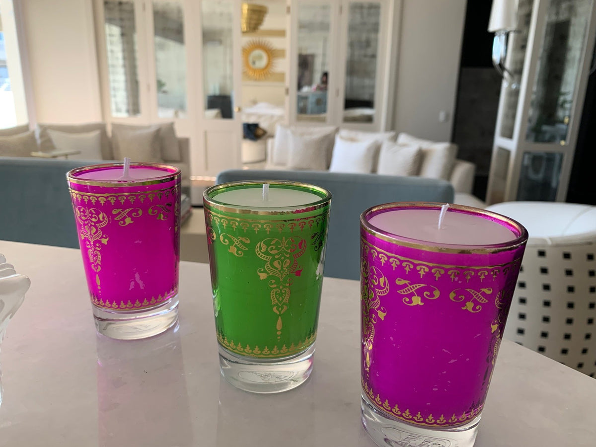 Candles in pink, green and purple glass tumblers
