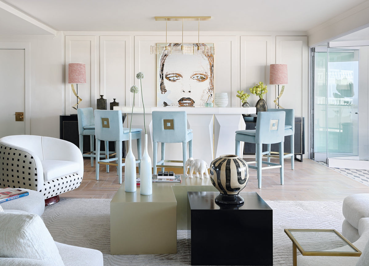 Portrait hanging above a white bar with pale blue stools in a bright Atlantic Seaboard living room