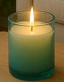Candle in a teal glass tumbler that fades to clear