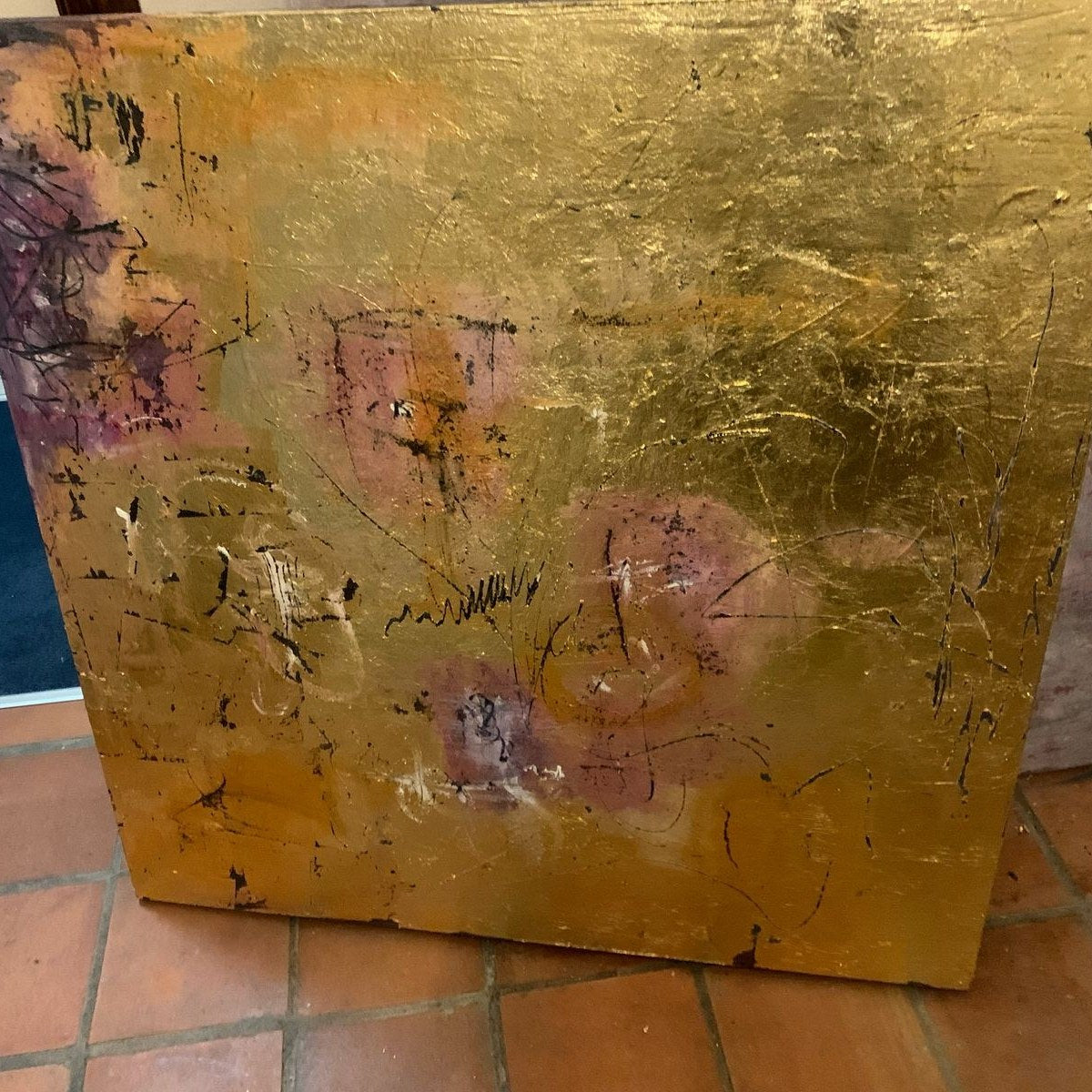 A gold leaf painting lying on terracotta tiles