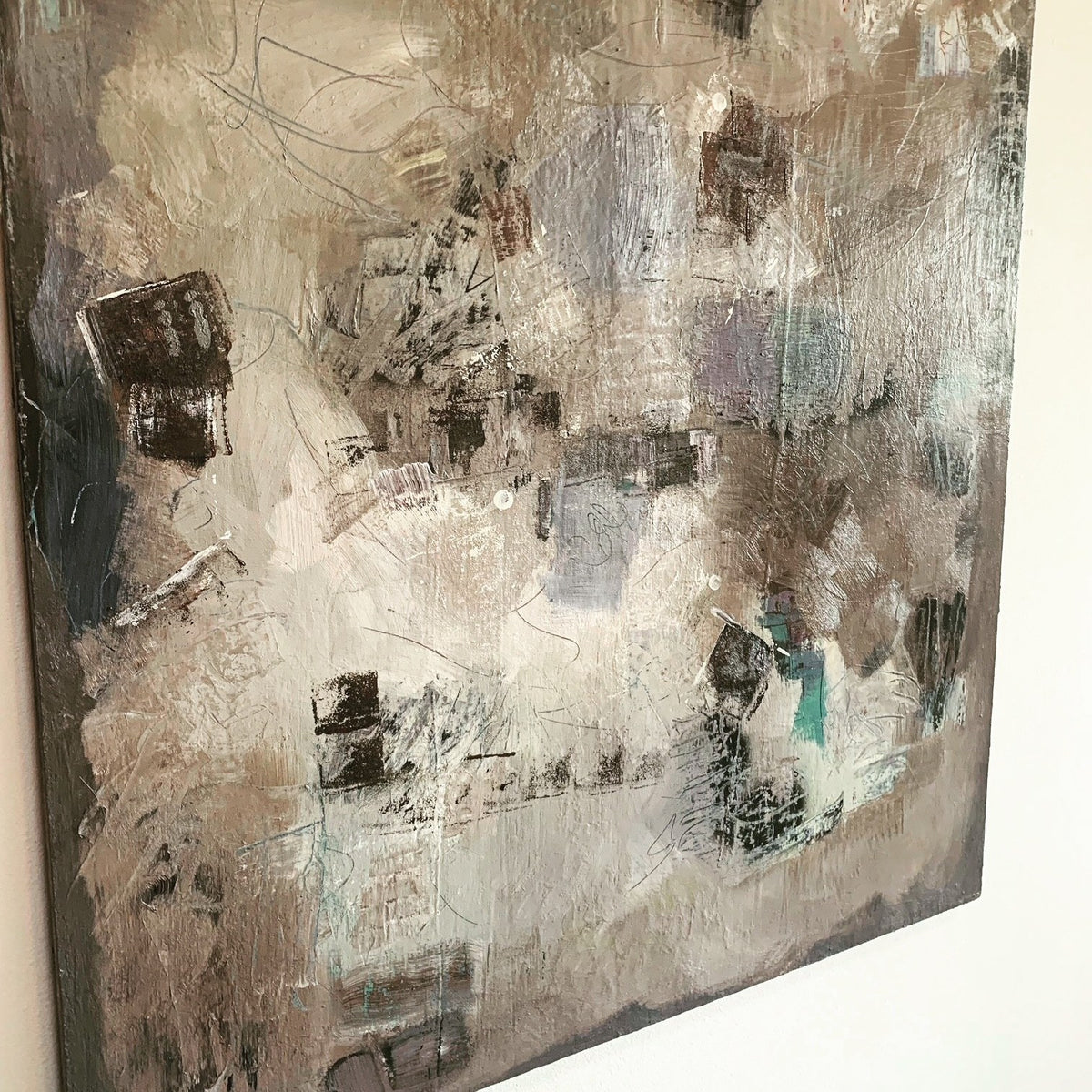 A grey and taupe painting drying on the studio wall